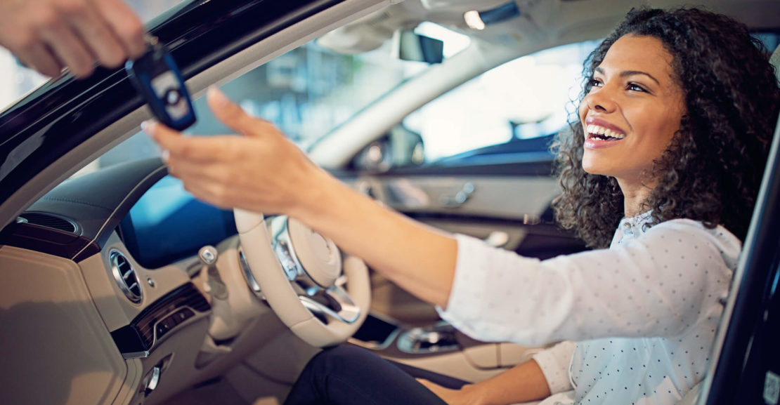 Foto de uma mulher dentro do carro recebendo a chave. IMagem para ilustrar o texto sobre como fazer um bom negócio ao comprar um carro
