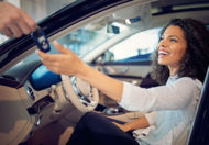 Foto de uma mulher dentro do carro recebendo a chave. IMagem para ilustrar o texto sobre como fazer um bom negócio ao comprar um carro