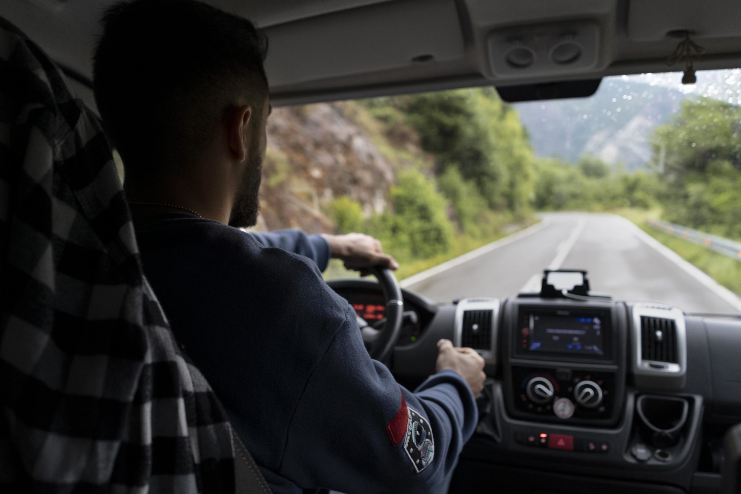 Homem ao volante de um carro na estrada