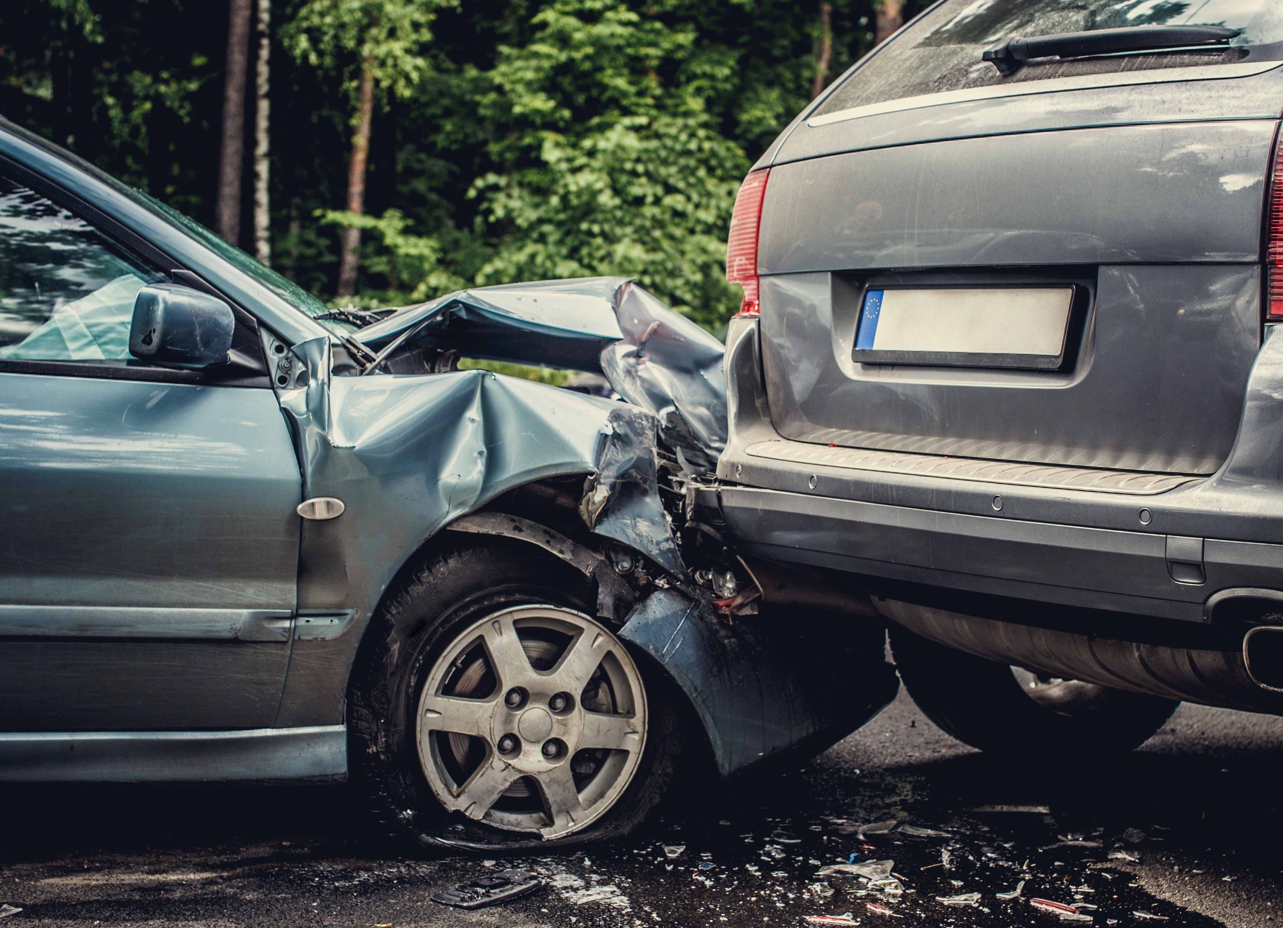 Imagem aproximada da parte dianteira de um carro batendo na parte traseira de outro carro em um acidente