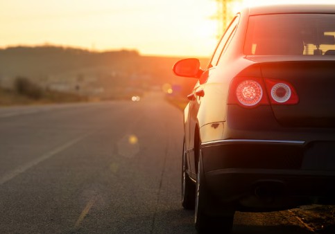 Carro de cor escura na estrada durante o por do sol