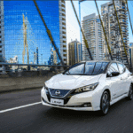 Carro modelo Nissan Leaf brancp andando na cidade